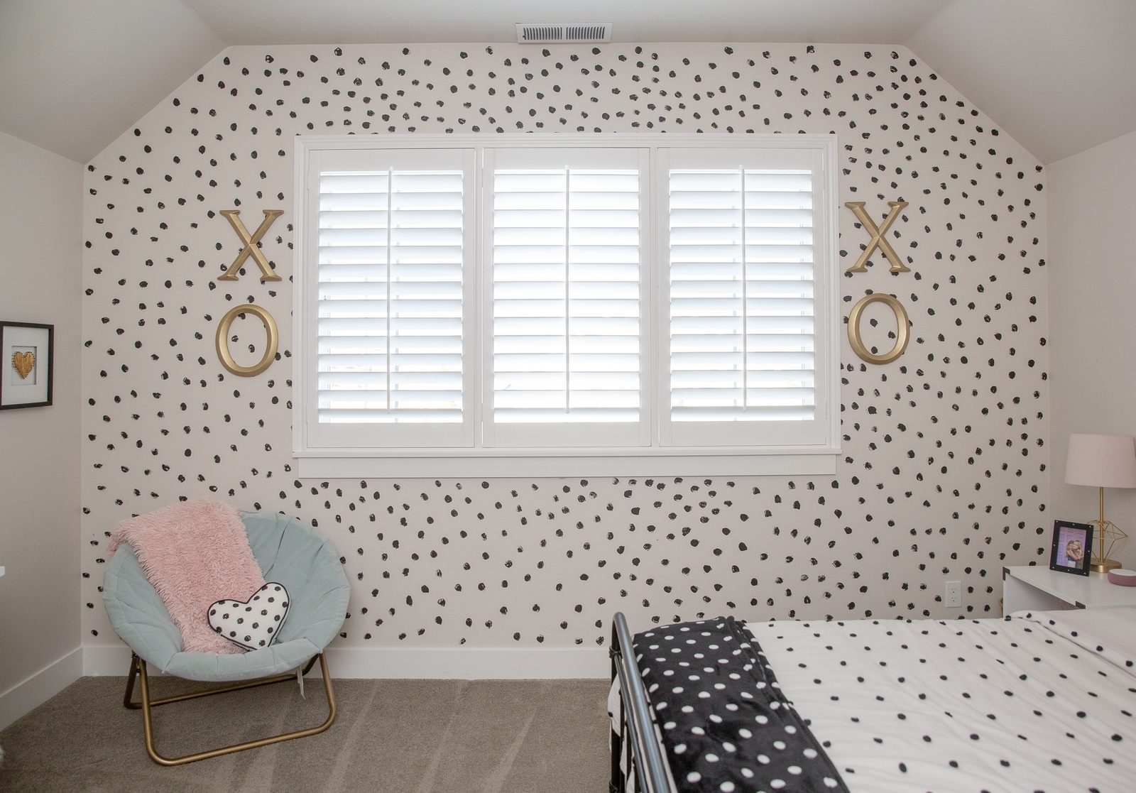 White plantation shutters in a girls bedroom
